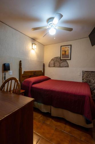 a hotel room with two beds and a ceiling fan at Hotel el Carmen, Morelia in Morelia