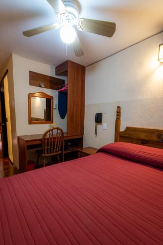 a hotel room with a bed and a desk at Hotel el Carmen, Morelia in Morelia
