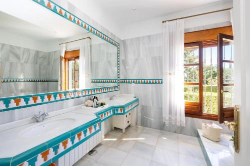 ein Bad mit einer Badewanne, einem Waschbecken und einem Fenster in der Unterkunft Alojamiento rural de lujo in Baza
