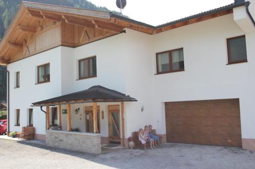 a large white house with a large garage at Landhaus Zell in Längenfeld