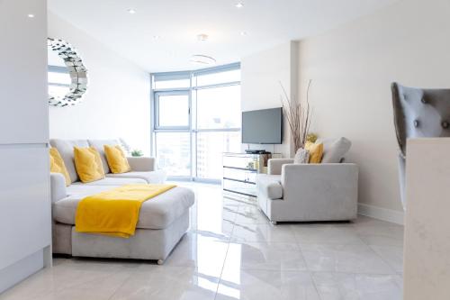 a white living room with a couch and a chair at Luxury Cardiff City Centre Apartments in Cardiff