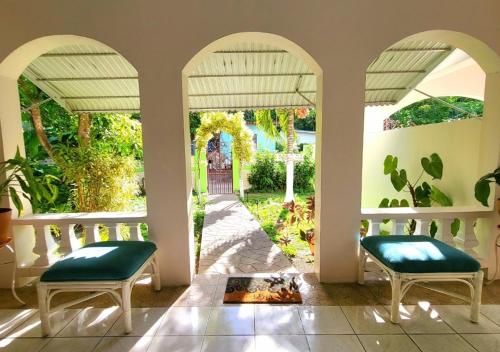 a porch with two chairs and a view of a yard at Green's Palace Jamaica in Oracabessa