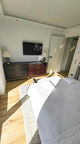 1 dormitorio con 1 cama grande y TV de pantalla plana en Luxus Neubau 65m2 City Wohnung - L, en Múnich