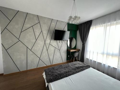 a bedroom with a white bed and a wall at Atractiv Apartaments in Chiajna