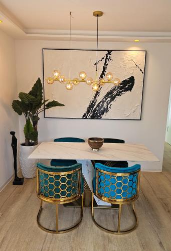 comedor con mesa y 2 sillas en Luxus Neubau 65m2 City Wohnung - L, en Múnich
