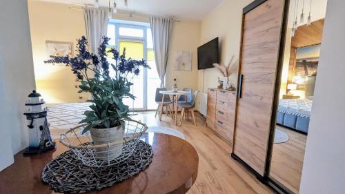 ein Schlafzimmer mit einem Bett und einem Tisch mit einer Topfpflanze in der Unterkunft Studio Appartment Heinze in Świnoujście