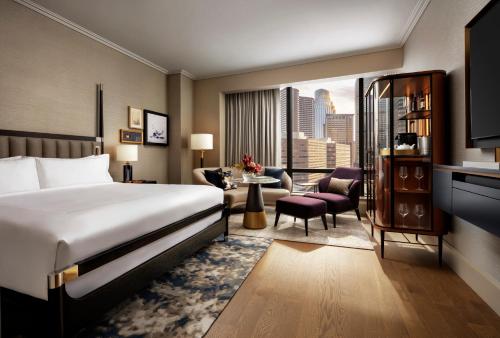 um quarto de hotel com uma cama e uma sala de estar em Raffles Boston em Boston