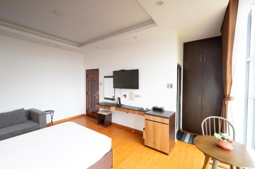 1 dormitorio con cama, sofá y TV en TTR Midtown View Hotel, en Da Lat