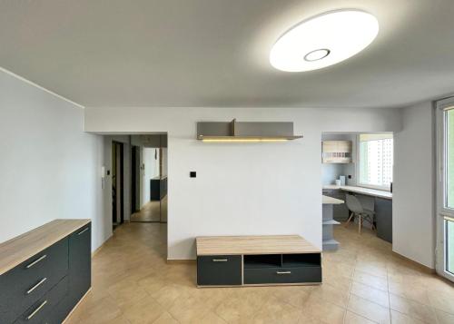 a living room with a table and a white wall at Łódź Manhattan Aparts -Ulica Piotrkowska in Łódź