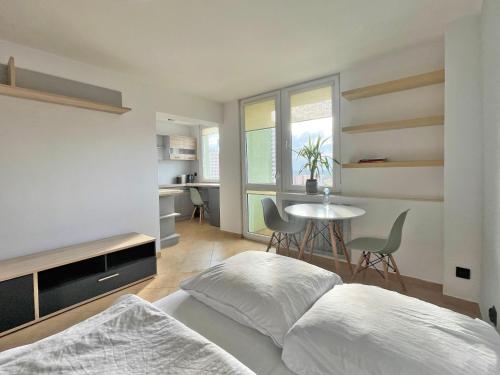 a bedroom with a bed and a table with chairs at Łódź Manhattan Aparts -Ulica Piotrkowska in Łódź