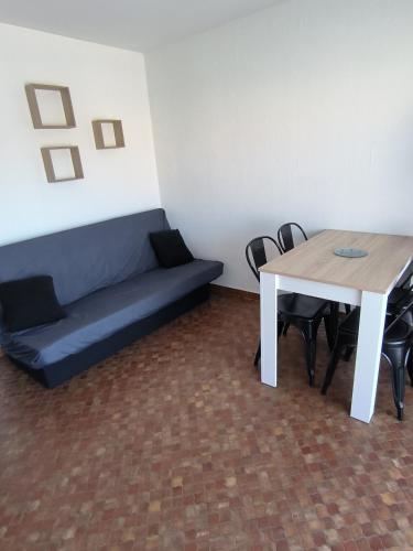 a living room with a couch and a table at Studio Cabine in Gruissan