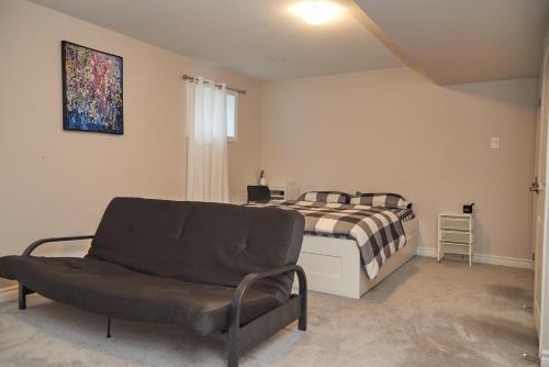a bedroom with a bed and a couch in it at Fully Furnished En-Suite Basement in Ottawa