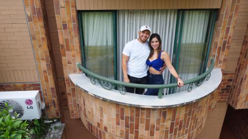 a man and a woman standing in a window at Hotel Palmera Real in Bucaramanga