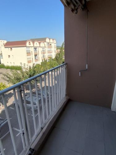 a balcony with a white railing and a building at Studio Cabine in Gruissan