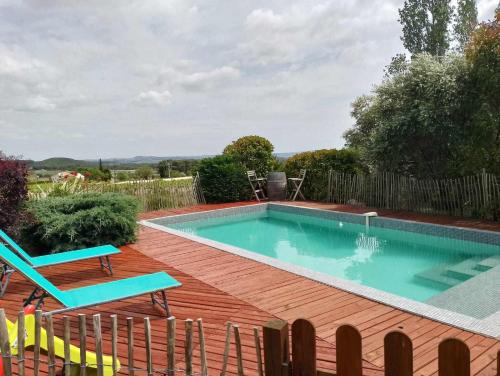 una piscina en una terraza de madera con una silla azul en Villa avec une piscine privée, en Quarante