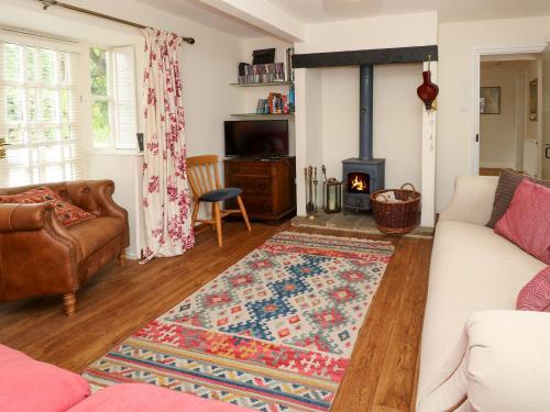 a living room with a couch and a fireplace at Frosthill Cottage in Newport