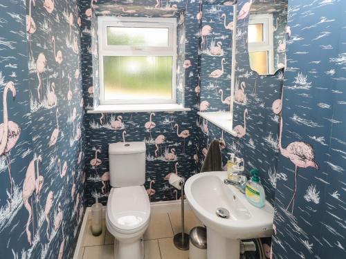 Frosthill Cottage في نيوبورت: حمام به فلامنغو وردي على الحائط
