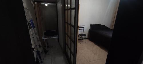 een kleine kamer met een bed en een deur naar een slaapkamer bij Quarto em casa a 1.4km da UFSM in Santa Maria