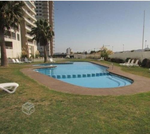 a large swimming pool in a yard next to a building at costa mansa 3200 in Coquimbo