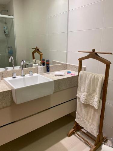 bagno con lavandino bianco e specchio di Aconchegante & charmoso a Rio de Janeiro