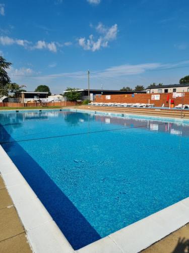 a large swimming pool with blue water at Modern Family Caravan with WiFi at Valley Farm, Clacton-on-Sea in Great Clacton