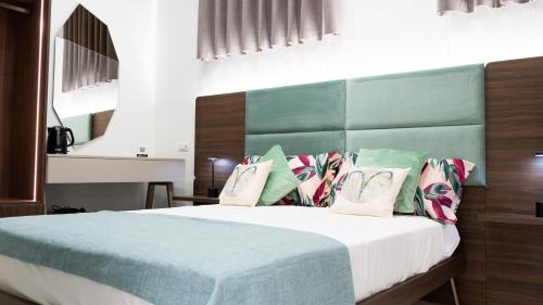 a bedroom with a bed with green and white pillows at Aries Suite Pompei in Pompei