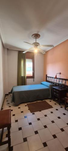 ein Schlafzimmer mit einem großen Bett und einem Deckenventilator in der Unterkunft Hostal El Molino in Calanda