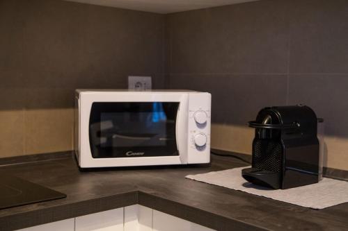 a microwave sitting on a counter next to a coffee maker at SUITE NAVIGLIO 26 in Parma