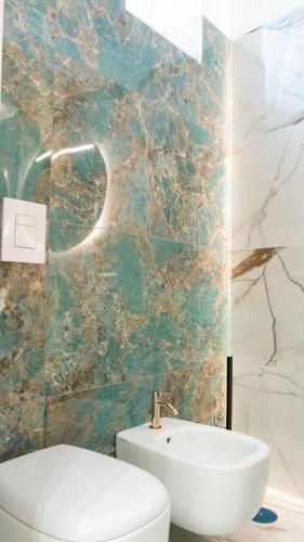 a bathroom with a white toilet and a sink at Aries Suite Pompei in Pompei
