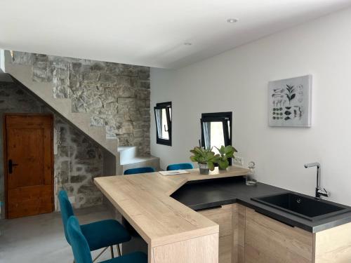 eine Küche mit einem Waschbecken und einer Theke mit blauen Stühlen in der Unterkunft Luxurious family house with pool in Ardèche. in Les Vans