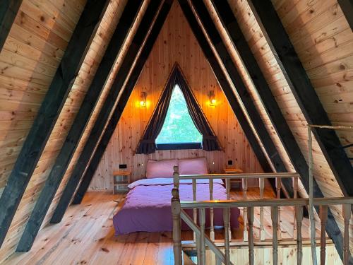 a bedroom in a log cabin with a bed in it at Çekirge Bungalov in Sakarya