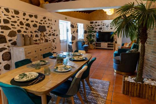 a dining room with a wooden table and chairs at O Refúgio in Praia