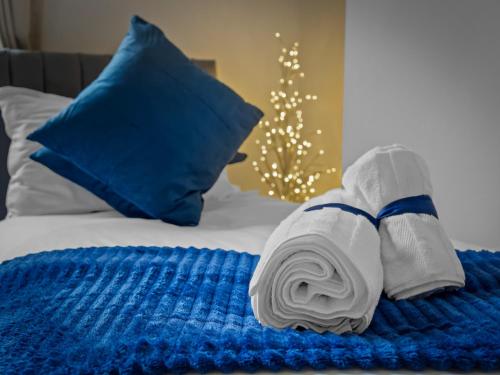 een opgerolde handdoek op een bed bij Preston Serviced Apartment - Estatevision in Preston