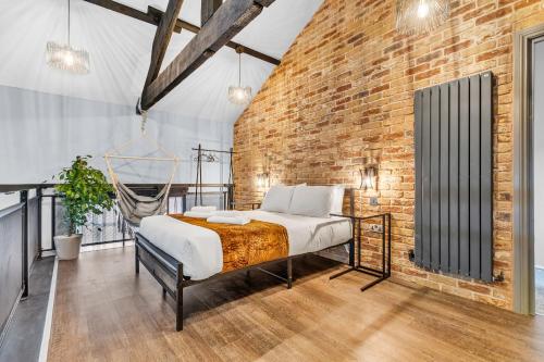 a bedroom with a bed in a brick wall at Luxe NY Loft-Style - Central Birmingham - 2BR - Lush Green Oasis in Birmingham