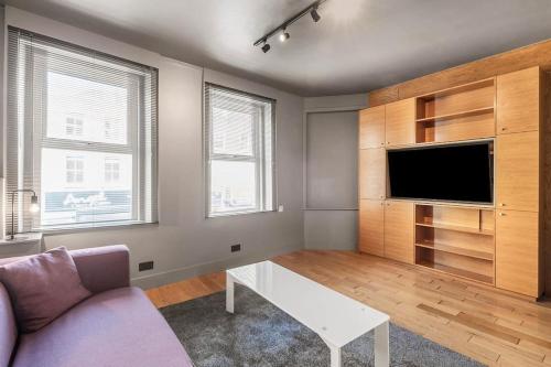 a living room with a couch and a flat screen tv at Spacious Home on Chapel Market in London
