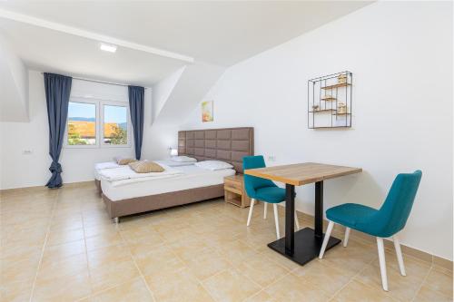 Apartments Lustica في تيفات: غرفة نوم بسرير وطاولة وكراسي