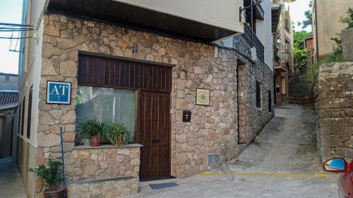 a stone building with a door on a street at AT la Abuela Antonia-El Gurugú in Torre de Don Miguel