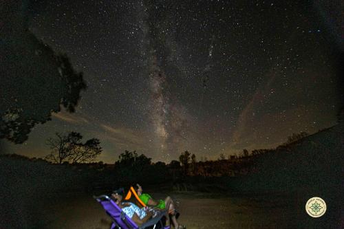 a group of people sitting on a sled under a starry sky at AT la Abuela Antonia-El Gurugú in Torre de Don Miguel