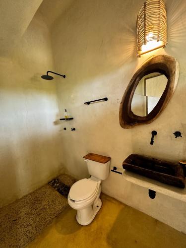 a bathroom with a toilet and a mirror at Casa Gitana in Chamuscadero