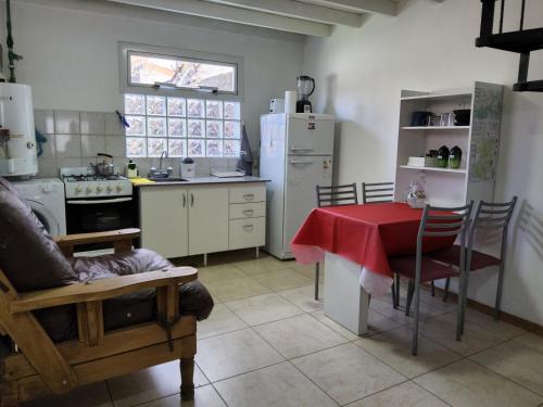 cocina con mesa y cocina con nevera en Quilmeña-al-Sur Departamento 1 en Esquel