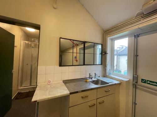 een badkamer met een wastafel en een spiegel aan de muur bij Grandma’s House in Walsall