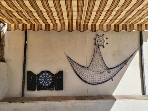 a hammock and a dart board on a wall at Casa Oasis Puertollano, una casa rural en Puertollano, agradable, con Piscina en zona tranquila in Puertollano