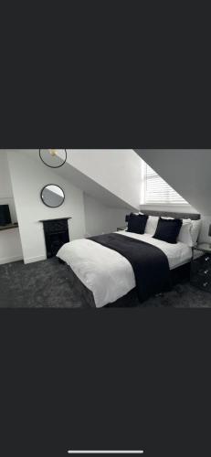 a bedroom with a large bed with black and white pillows at Bloww lodge in Oulton