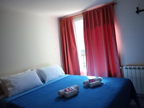 1 dormitorio con 1 cama azul y 2 toallas en Departamento DON ALBERTO en El Calafate