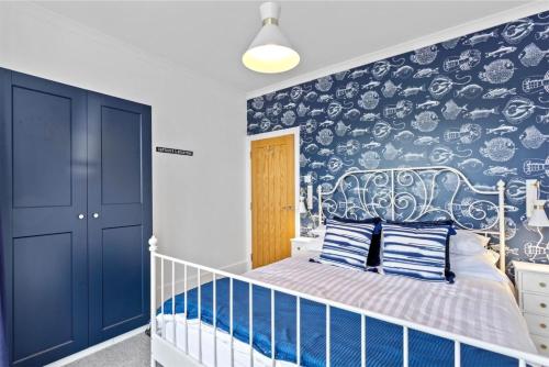 una camera da letto per bambini con carta da parati blu e bianca di Captain's Quarters a Hythe