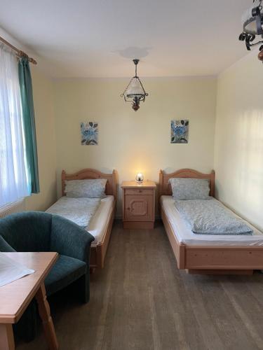 una camera con due letti, un divano e un tavolo di Landgasthof - Braukeller - Fattigau a Oberkotzau