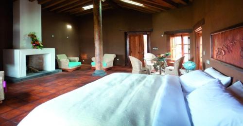 a large bedroom with a large bed and a fireplace at Hacienda Ucazanaztacua in Pátzcuaro
