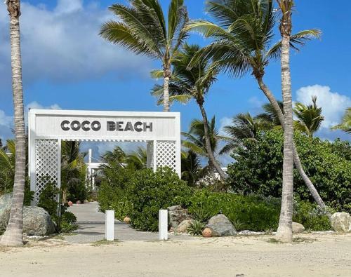 a sign that says cocoa beach with palm trees at Orient Bay Villa in Orient Bay