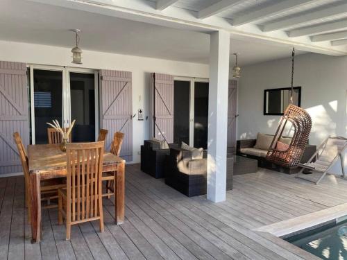 a patio with a table and chairs and a living room at Orient Bay villa in Saint Martin