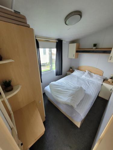 a small bedroom with a bed and a window at 72 Holiday Resort Unity Brean Centrally Located - Resort Passes Included - Pet Stays Free No workers Sorry in Brean